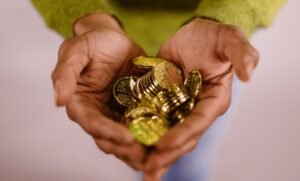 hands cupping a collection of gold coins