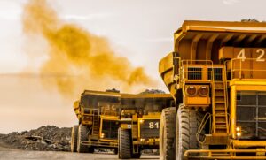 Three large mining trucks leaving mining operation