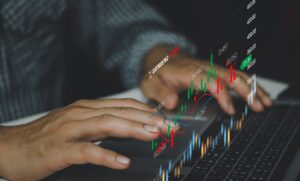 man at keyboard looking at price charts