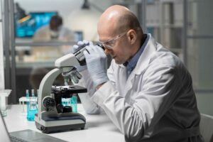 a man looking through a microscope