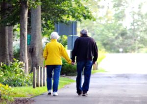 baby boomer couple holding hands walking down the street