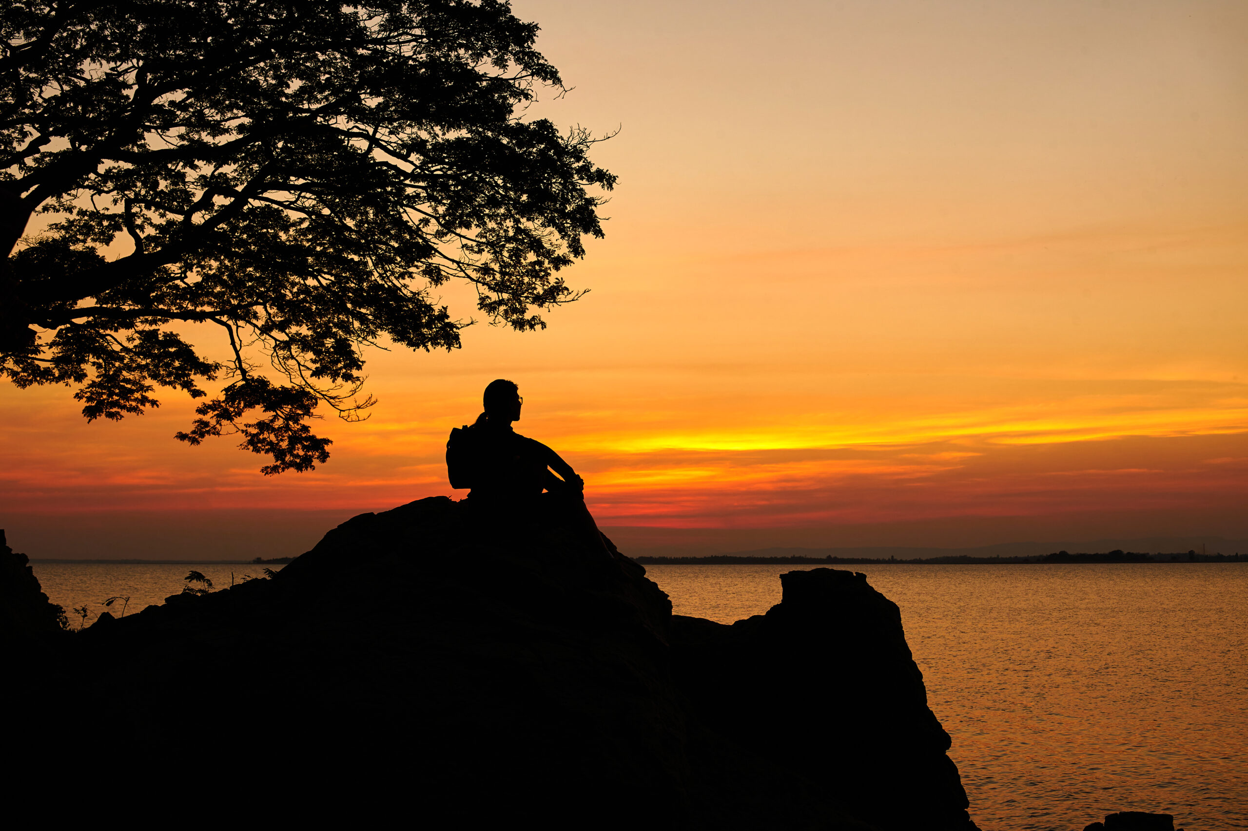 silhouette-scene-of-a-woman-sitting-on-a-big-rock-2023-11-27-04-48-18-utc